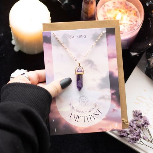 Gold-tone amethyst crystal necklace on a greeting card, perfect for relaxation and mindfulness gifts