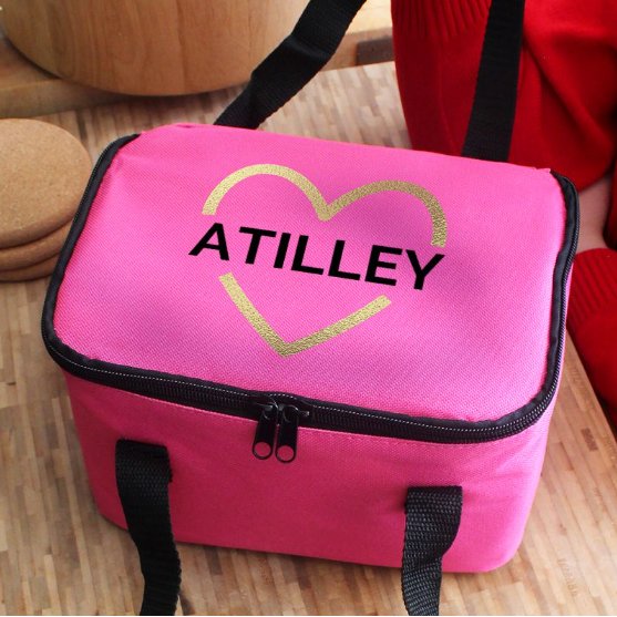 Pink bag with 'ATILLEY' branding on a wooden surface