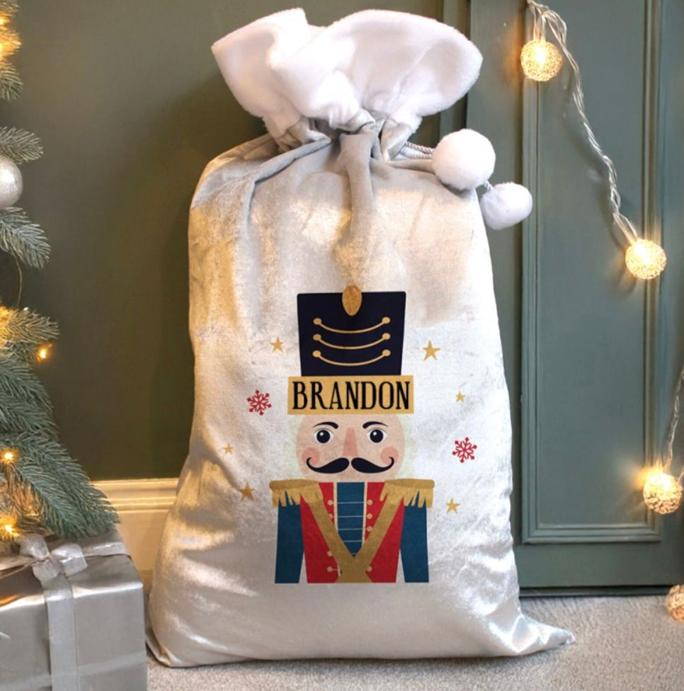 Personalised Christmas gift bag with nutcracker design and 'Brandon' text, placed against a festive background.