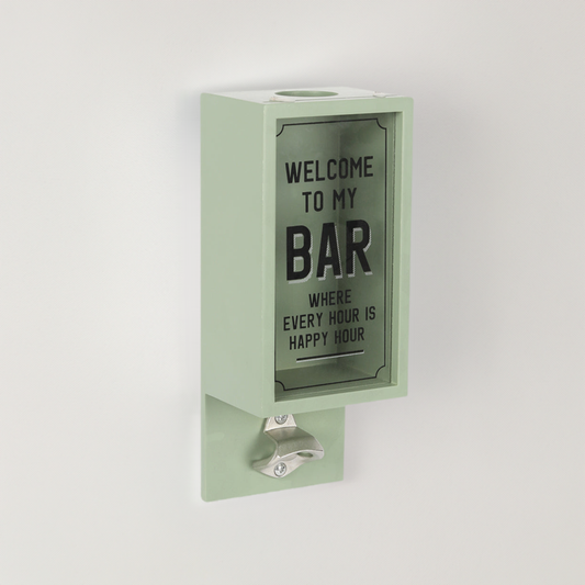 A wall mounted bottle opener with words ‘welcome to my bar’ and a box for collecting lids