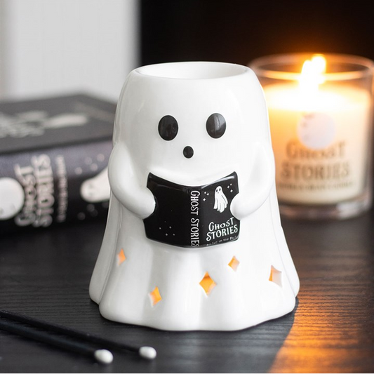 Ghost-shaped oil & wax burner with a lit candle in the background