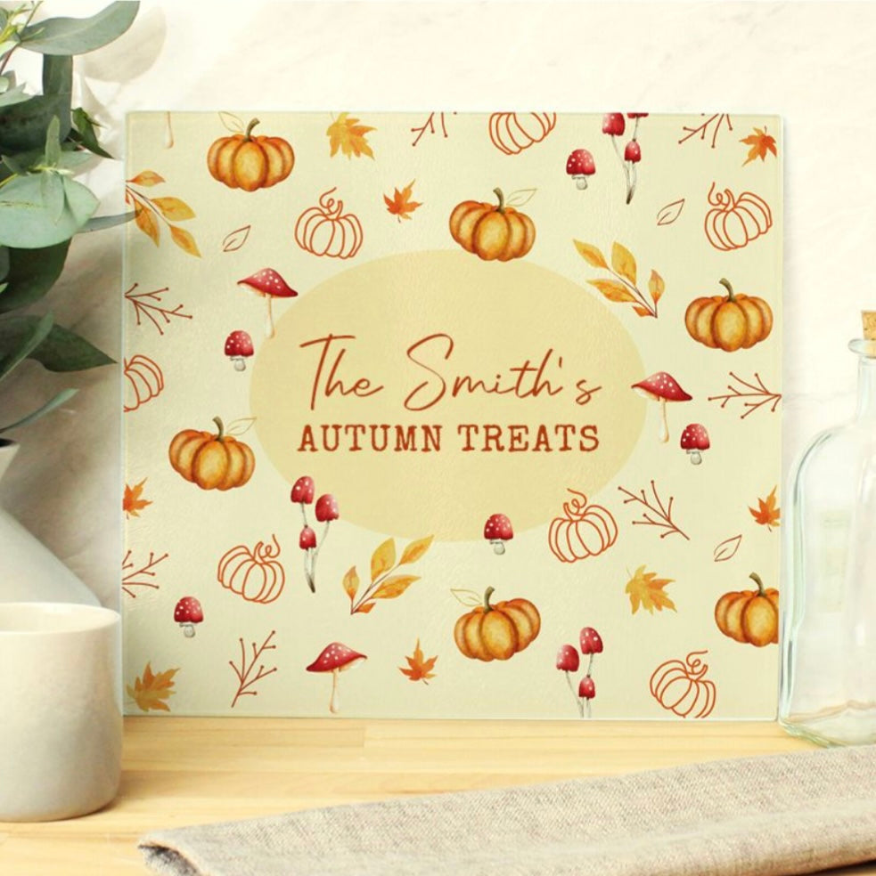 Autumn-themed chopping board with pumpkins and leaves on a neutral background and room in the middle for personalised name and wording