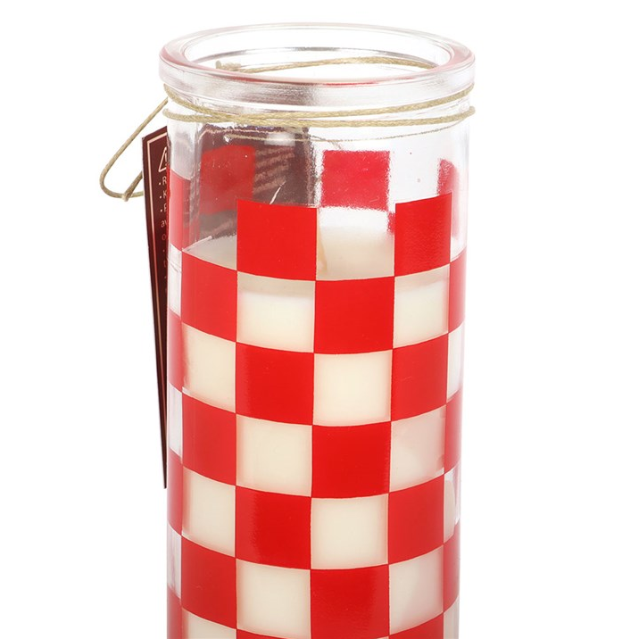 Candle in a glass jar with red and white checkered pattern on a white background