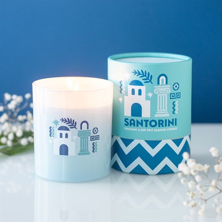 Candle and its packaging with 'Santorini' design on a blue background