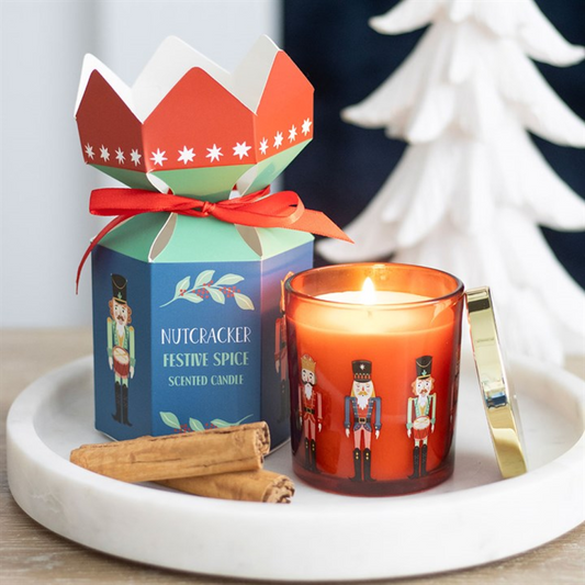 Festive candle with Nutcracker design and packaging on a marble tray.