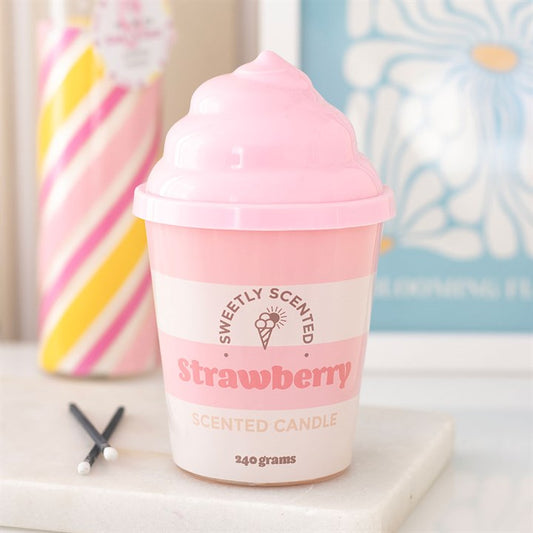 Pink strawberry scented candle in a cup with decorative background