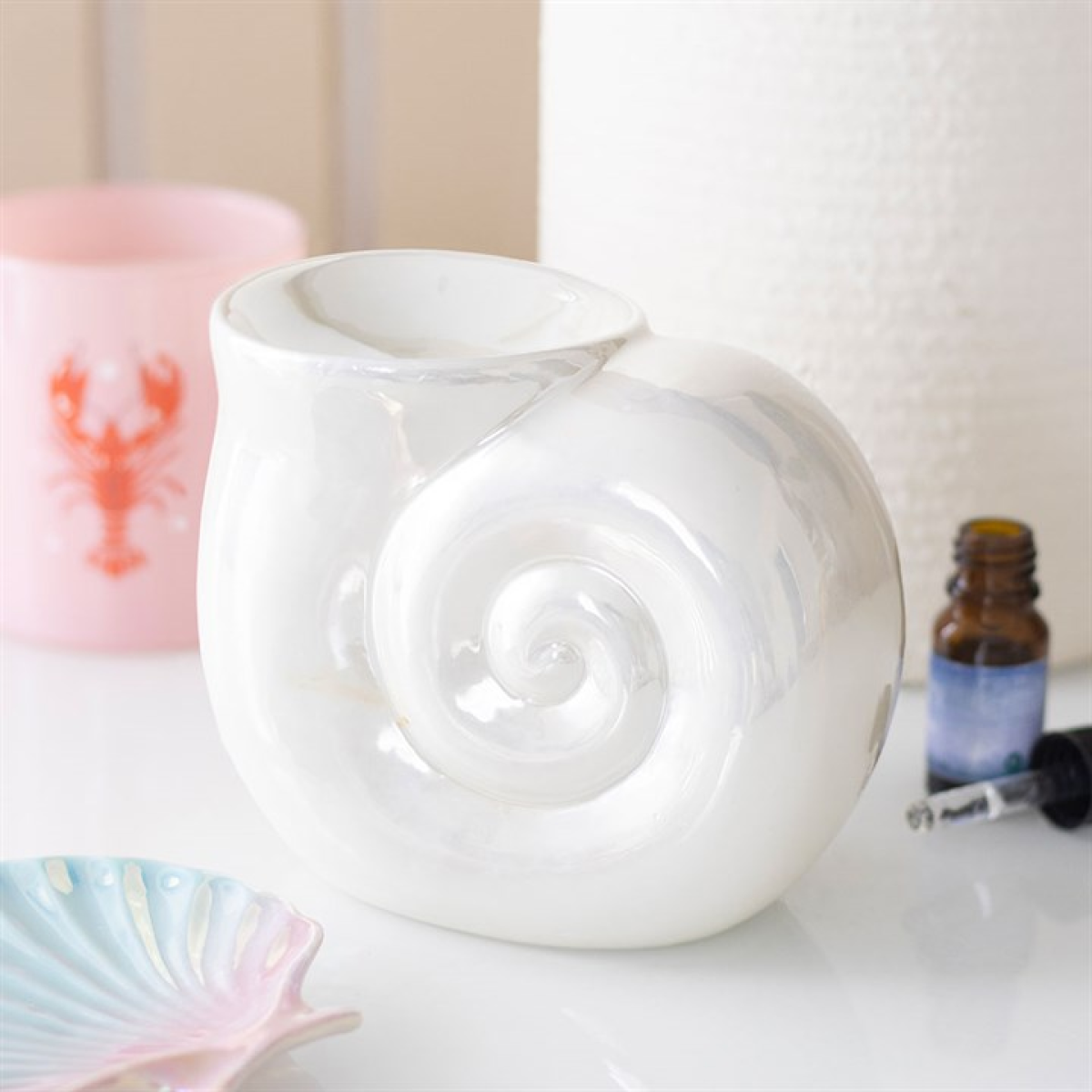 White ceramic diffuser with a bottle of essential oil on a light surface