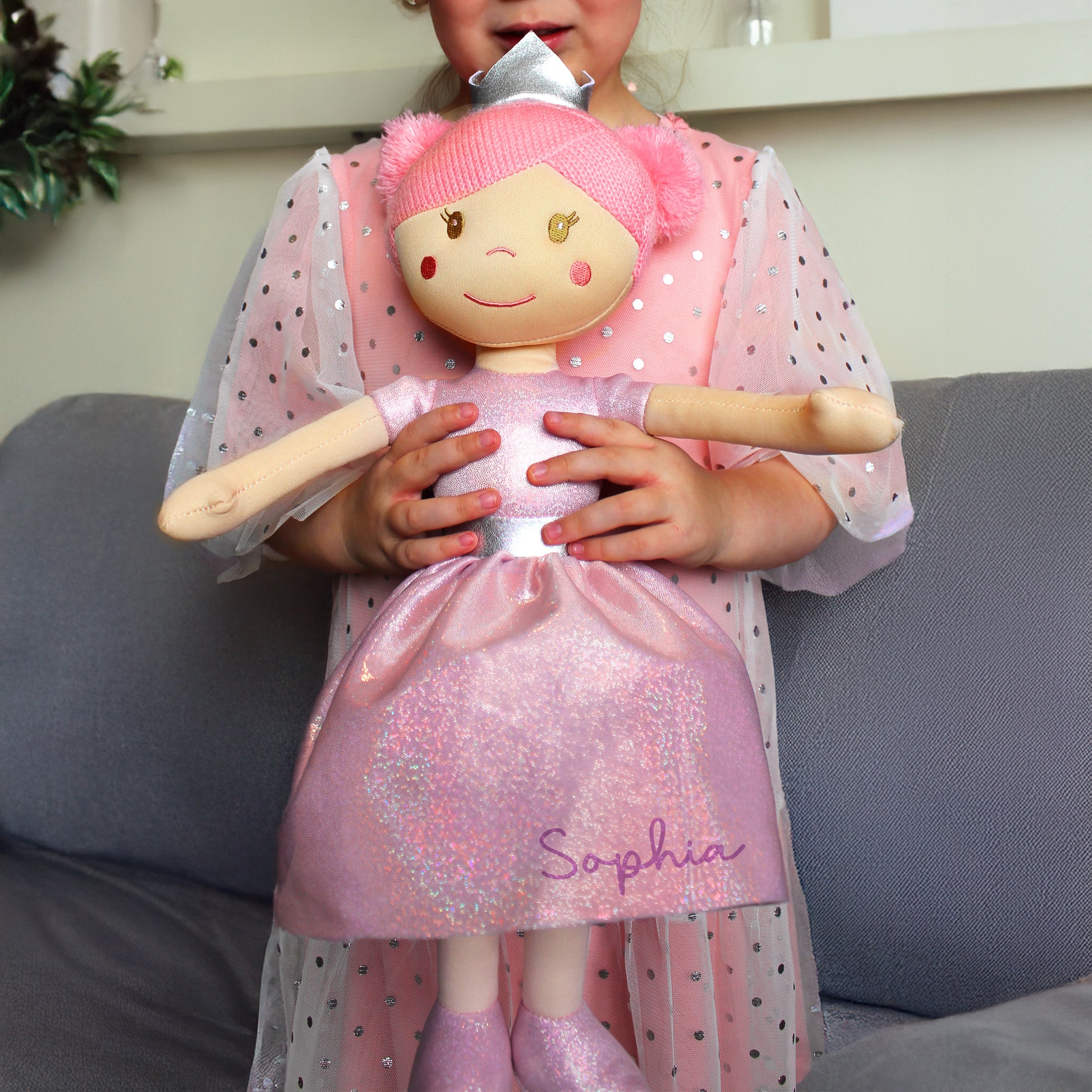 Child holding a doll personalised with a name