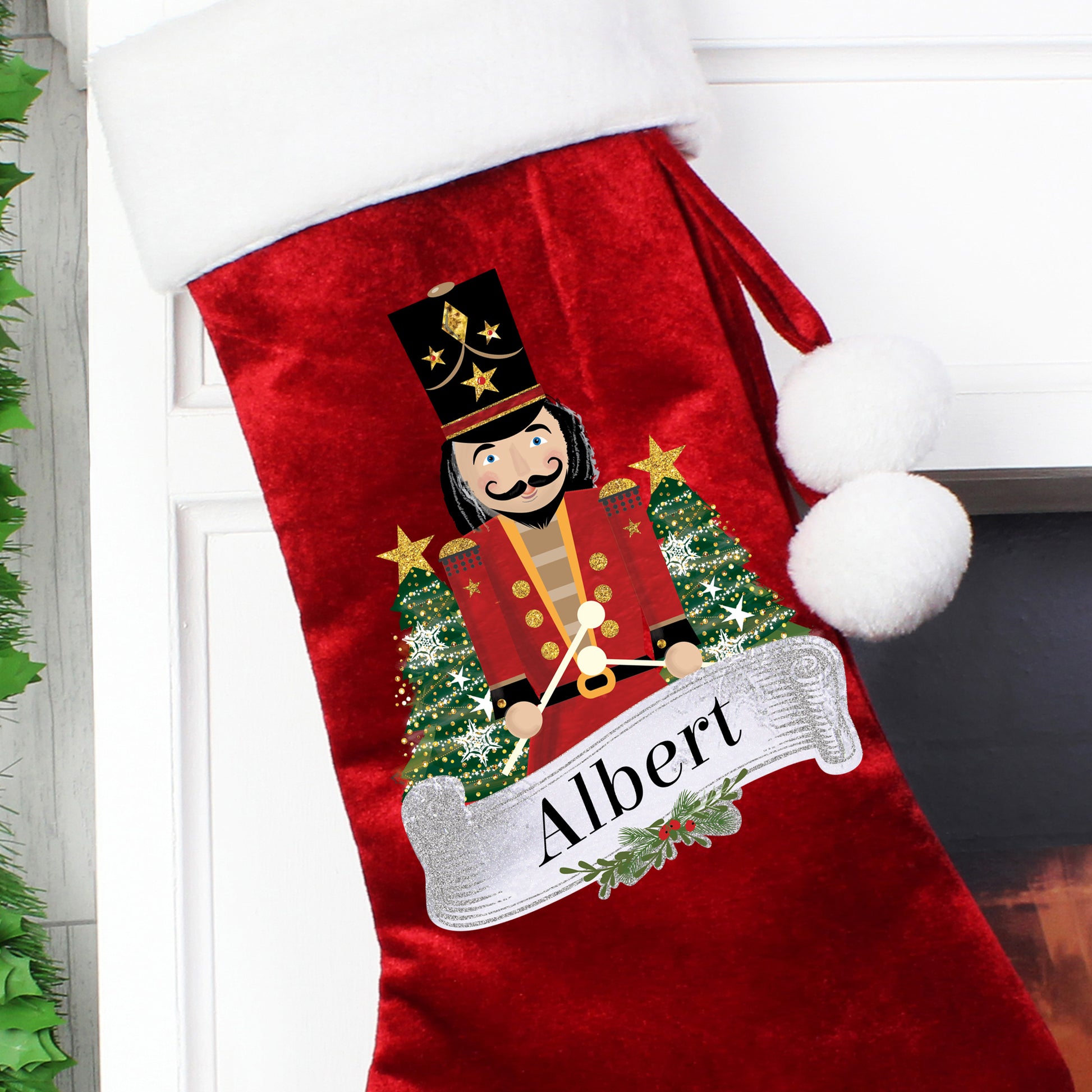 Red Christmas stocking with a Nutcracker design and 'Albert' text, hanging on a fireplace.