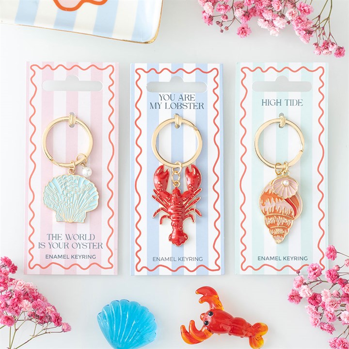 Three enamel keyrings in packaging with floral decorations
