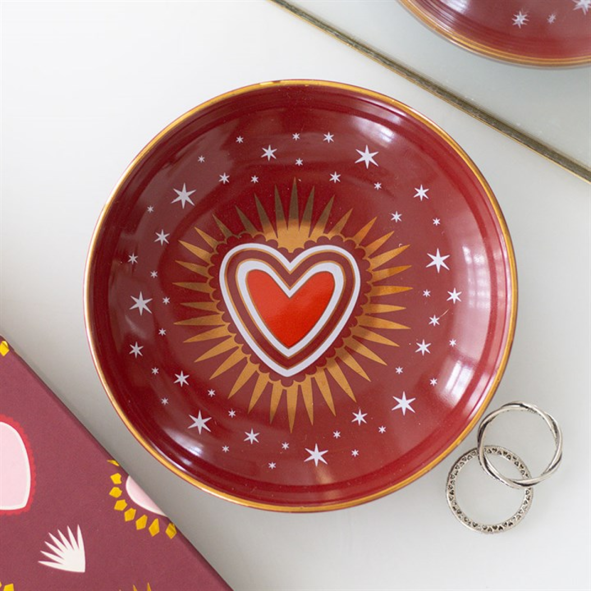 Red decorative plate with a heart design on a white surface