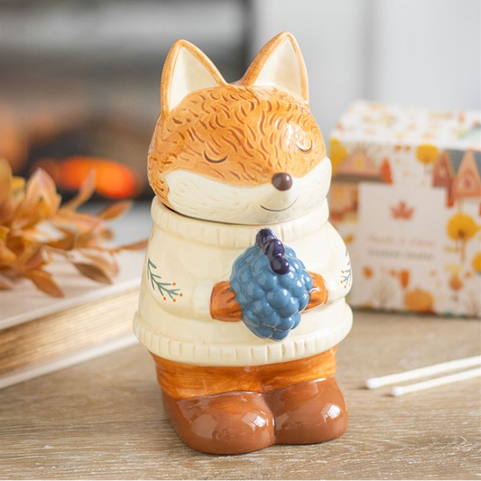 Fox-shaped oil & wax burner with a blueberry on a wooden surface