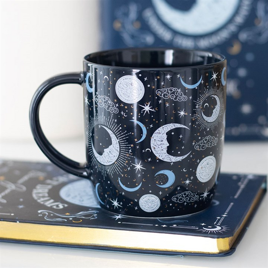 Navy mug with celestial design on a matching book